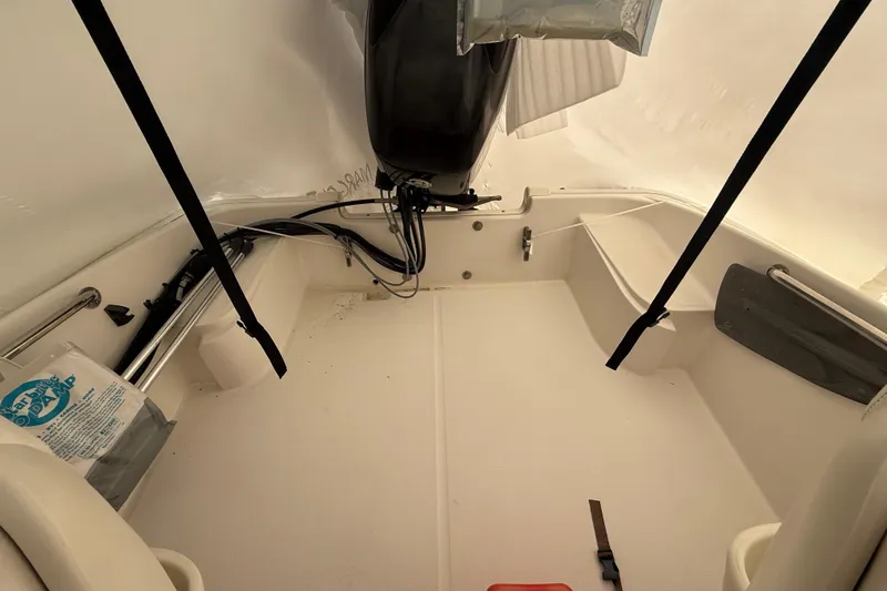 Slide: The Image of 2011 Boston Whaler 150 Super Sport boat interior with motor and storage compartments. - 3