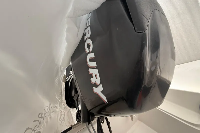 Slide: The Image of 2011 Boston Whaler 150 Super Sport with Mercury outboard engine, partially covered. - 5