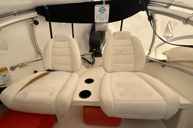 Slide: The Image of 2011 Boston Whaler 150 Super Sport interior with white seats and cup holders. - 9