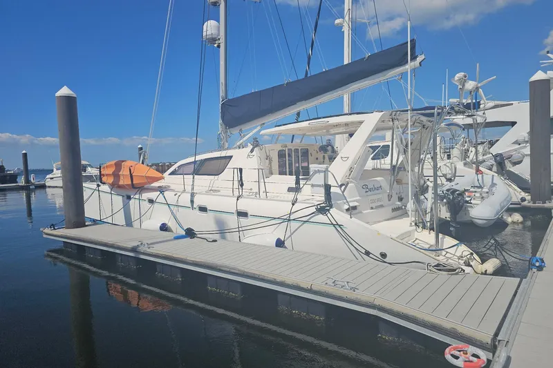 Slide: The Image of 2004 Leopard 47 catamaran docked at marina under clear blue sky. - 0
