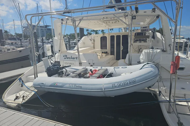 Slide: The Image of 2004 Leopard 47 catamaran docked with inflatable dinghy, Coconut Grove, sunny marina setting. - 1