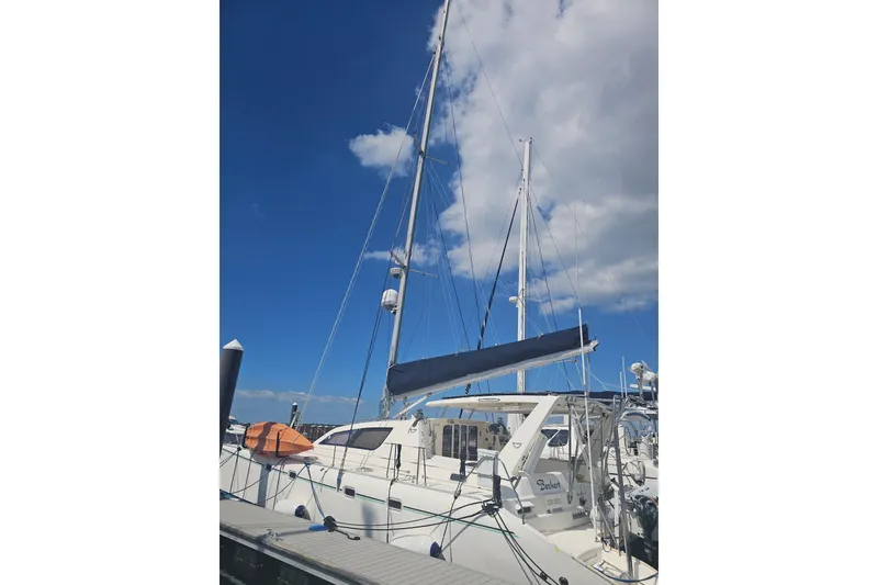 Slide: The Image of 2004 Leopard 47 catamaran docked under a clear blue sky. - 102