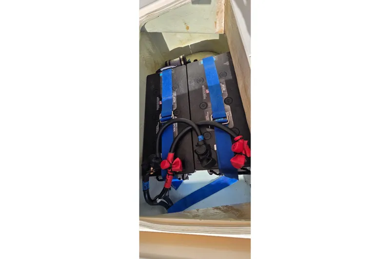 Slide: The Image of Battery compartment of a 2004 Leopard 47 yacht, secured with blue straps. - 12