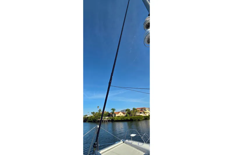 Slide: The Image of Sailboat view from Leopard 47, 2004 model, with clear blue sky and waterfront homes. - 18