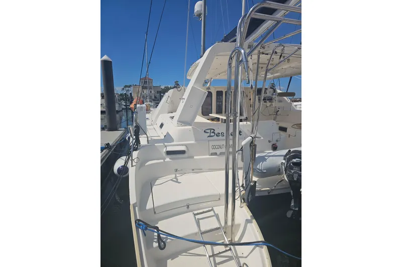 Slide: The Image of 2004 Leopard 47 catamaran docked at marina, featuring spacious deck and modern design. - 2