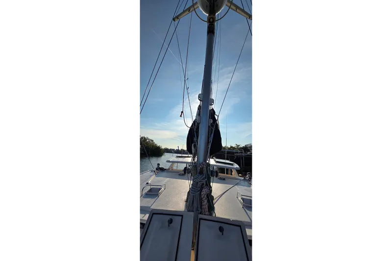 Slide: The Image of 2004 Leopard 47 catamaran on calm water, showcasing mast and deck under clear sky. - 22