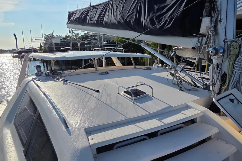 Slide: The Image of 2004 Leopard 47 catamaran deck with rigging, docked in a sunny marina. - 23