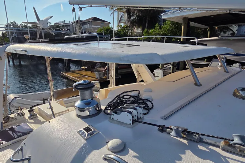 Slide: The Image of 2004 Leopard 47 yacht deck with winch and ropes, docked near waterfront homes. - 28