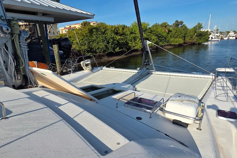 Slide: The Image of 2004 Leopard 47 catamaran docked by lush greenery and calm waters. - 30