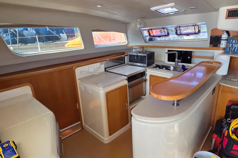 Slide: The Image of Interior of 2004 Leopard 47 catamaran kitchen with modern appliances and wooden accents. - 38