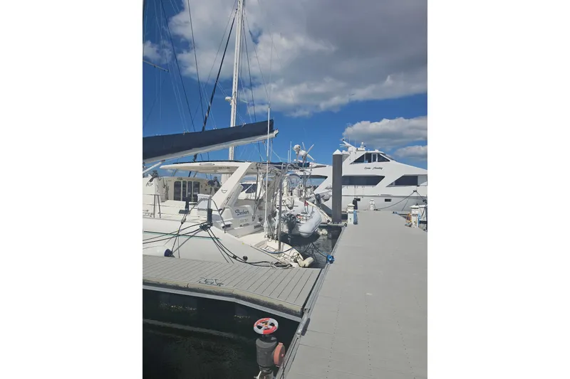 Slide: The Image of Docked 2004 Leopard 47 catamaran under blue sky with clouds. - 4