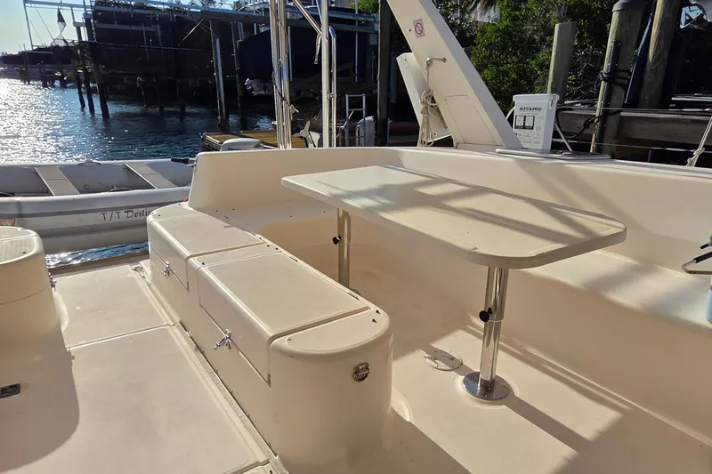 Slide: The Image of 2004 Leopard 47 yacht deck with seating and table, docked by the water. - 43