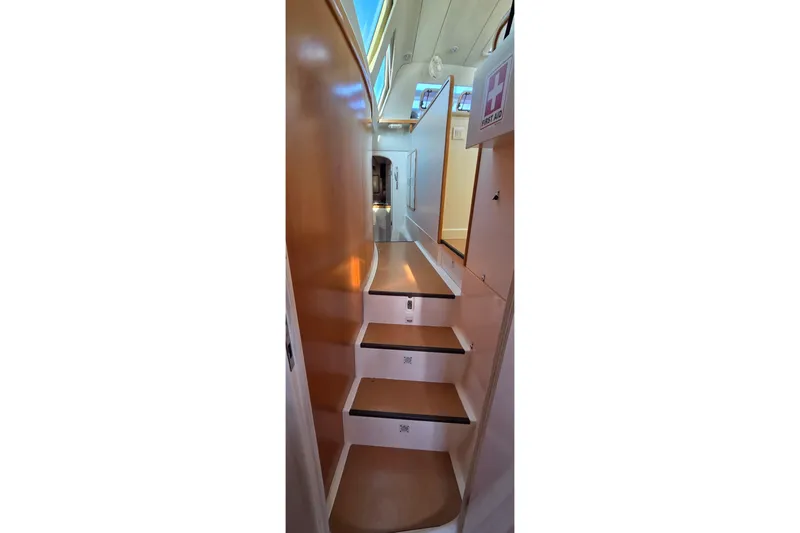 Slide: The Image of Interior stairs of 2004 Leopard 47 yacht, featuring sleek design and first aid kit. - 54
