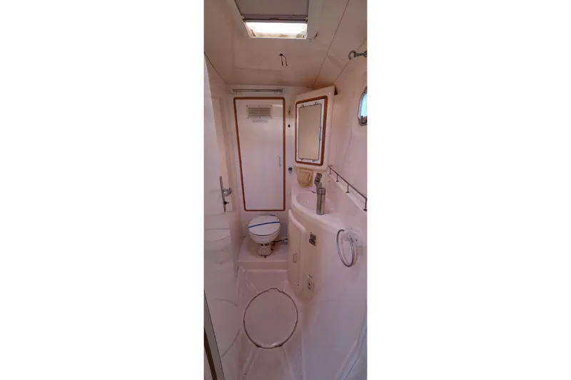 Slide: The Image of Bathroom interior of a 2004 Leopard 47 yacht, featuring a toilet and sink. - 56
