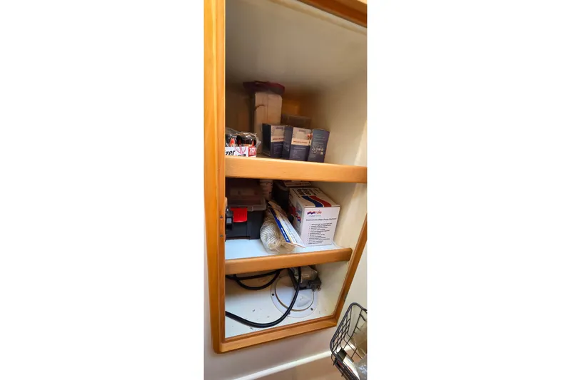 Slide: The Image of Storage cabinet on a 2004 Leopard 47 yacht, containing various supplies and equipment. - 58