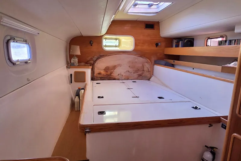 Slide: The Image of Interior of a 2004 Leopard 47 catamaran cabin with wooden accents and storage space. - 67