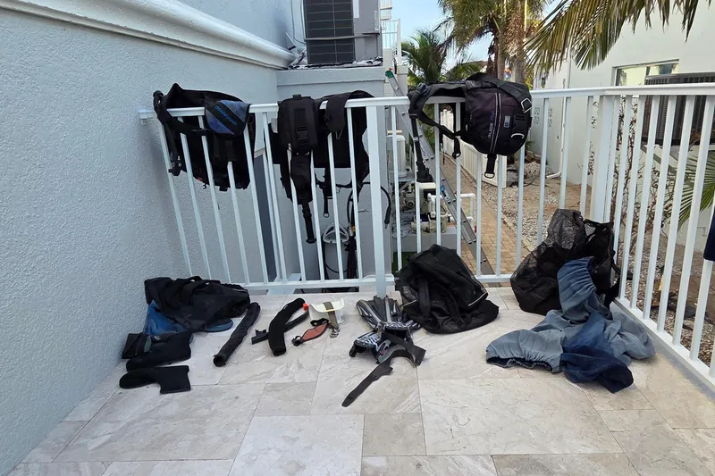 Slide: The Image of Diving gear drying on a balcony, including wetsuits and fins, near a Leopard 47 catamaran. - 79