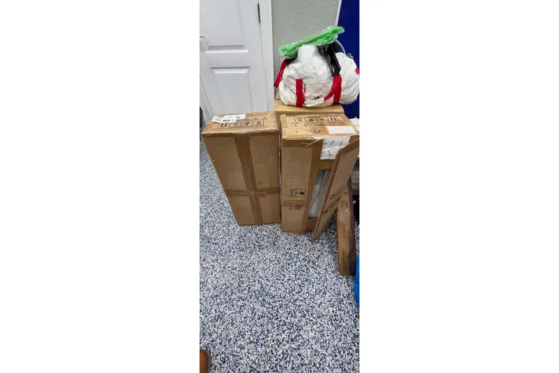 Slide: The Image of Cardboard boxes and bags on speckled floor, near a white door. - 85