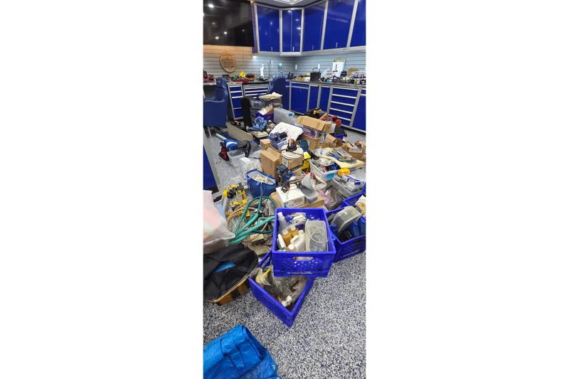 Slide: The Image of Workshop with scattered tools and supplies, featuring blue cabinets and organized storage. - 86