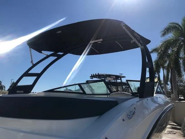 Slide: The Image of 2022 Sea Ray SPX 190 OB boat with canopy, sunny day, palm trees in background. - 17
