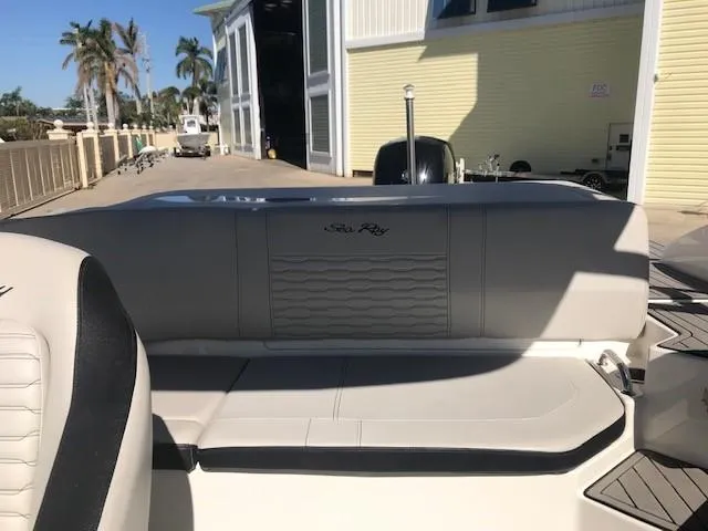 Slide: The Image of 2022 Sea Ray SPX 190 OB boat interior with seating, docked near palm trees. - 25