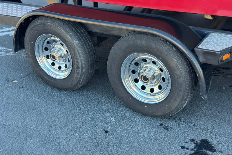 Slide: The Image of Trailer wheels of a 2012 Malibu Wakesetter 21 VLX on asphalt surface. - 30