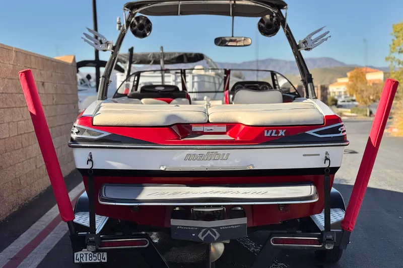 Slide: The Image of 2012 Malibu Wakesetter 21 VLX boat, rear view, parked outdoors with red accents. - 4