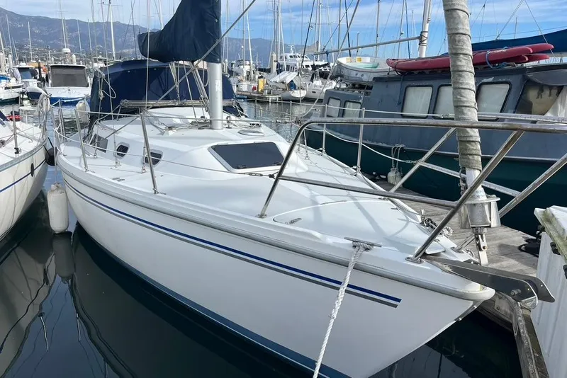 Slide: The Image of Catalina 30 sailboat, 2003 model, docked in a marina with surrounding boats. - 2
