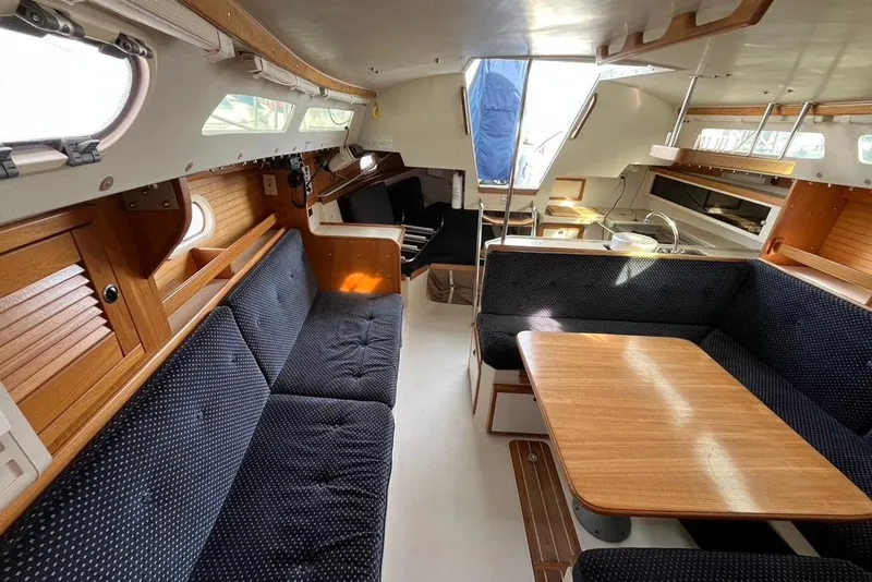 Slide: The Image of Interior of 2003 Catalina 30 sailboat with cozy seating and wooden table. - 7