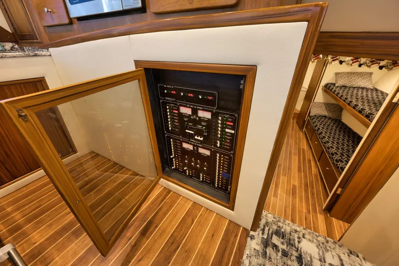 Slide: The Image of Electrical panel inside 2004 Guthrie 60 Custom Carolina yacht, featuring wooden flooring and cozy cabin. - 26