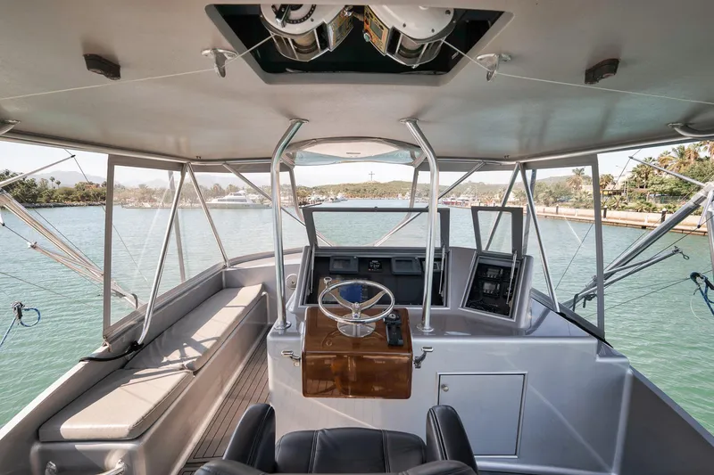 Slide: The Image of Helm of 2004 Guthrie 60 Custom Carolina boat with scenic waterway view. - 51