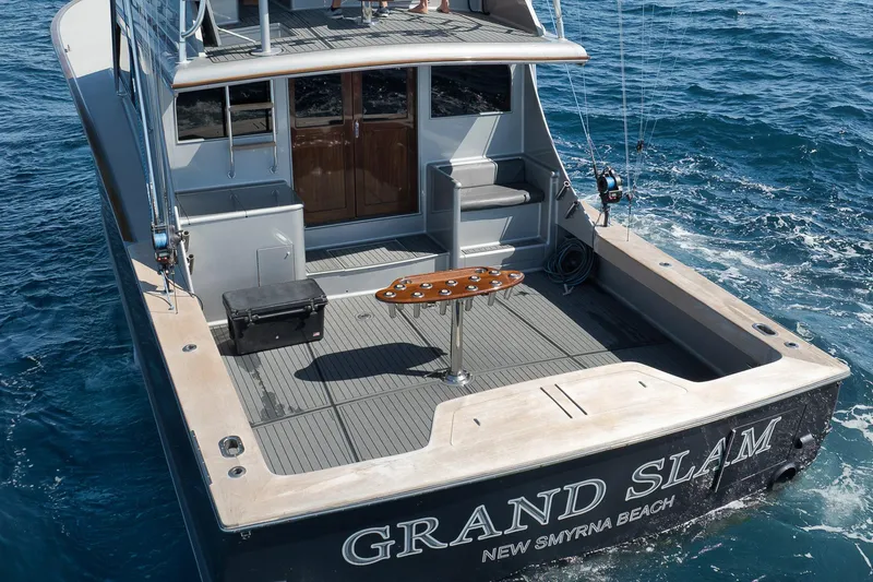 Slide: The Image of 2004 Guthrie 60 Custom Carolina yacht on ocean, featuring spacious deck and fishing equipment. - 56