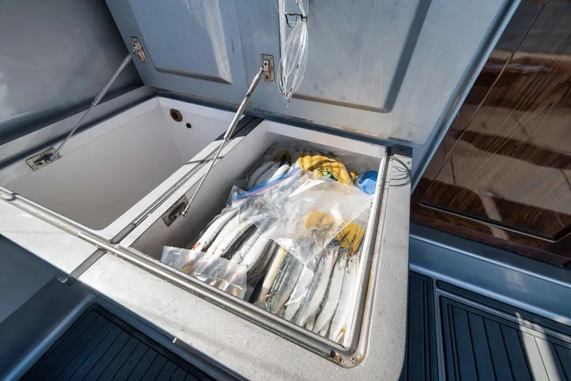 Slide: The Image of Open storage compartment on 2004 Guthrie 60 Custom Carolina boat with fishing gear. - 61