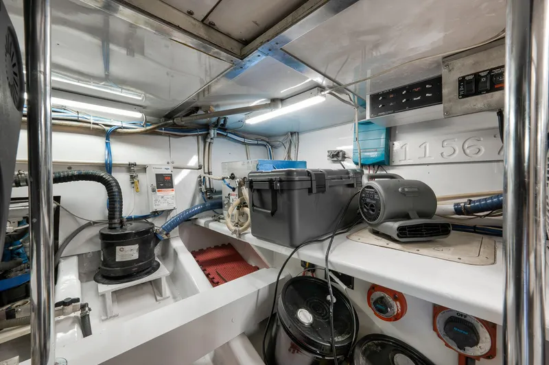 Slide: The Image of Engine room of 2004 Guthrie 60 Custom Carolina boat, featuring equipment and storage. - 73