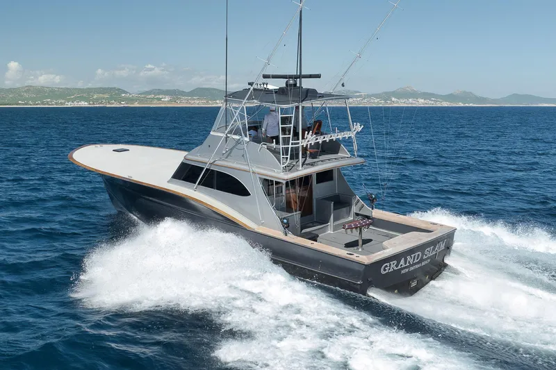 Slide: The Image of 2004 Guthrie 60 Custom Carolina yacht cruising on open sea, labeled "Grand Slam." - 77