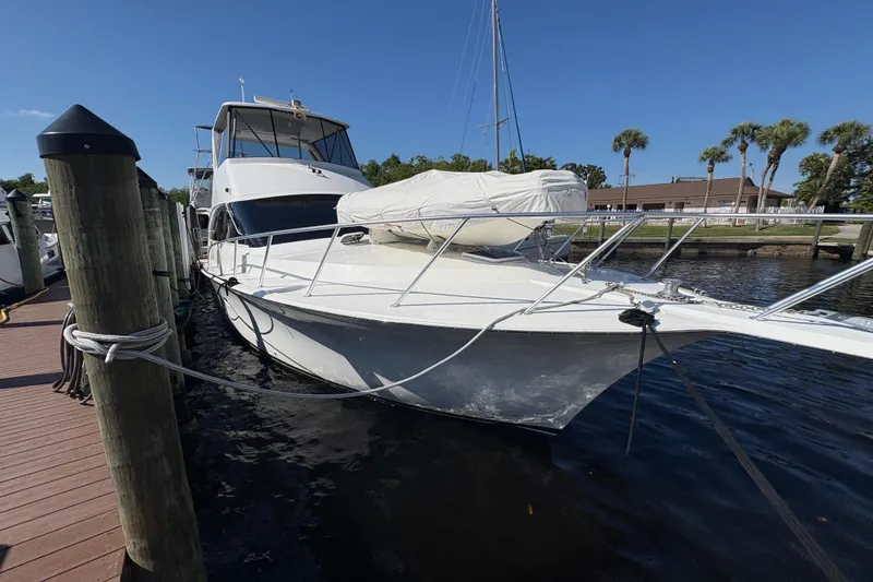 Slide: The Image of 1996 Ocean Yachts 48 Super Sport docked at marina under clear blue sky. - 2