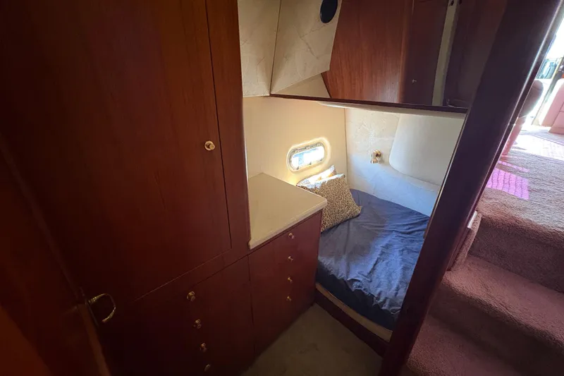 Slide: The Image of 1996 Ocean Yachts 48 Super Sport cabin interior with bed, wooden cabinets, and window. - 22