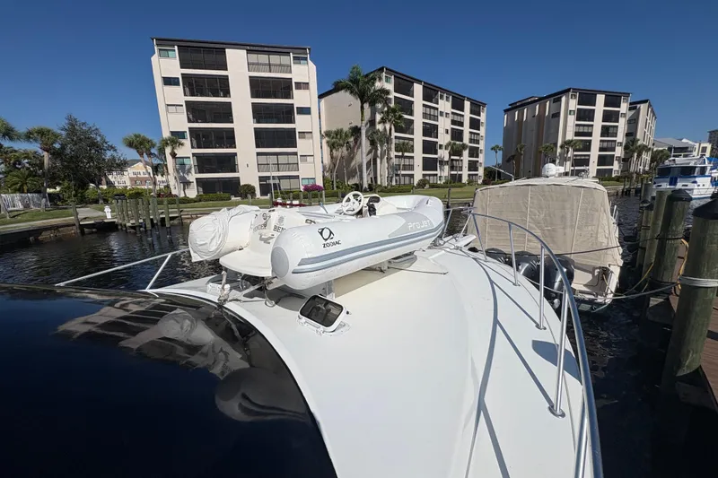Slide: The Image of 1996 Ocean Yachts 48 Super Sport docked near waterfront buildings under clear blue sky. - 37