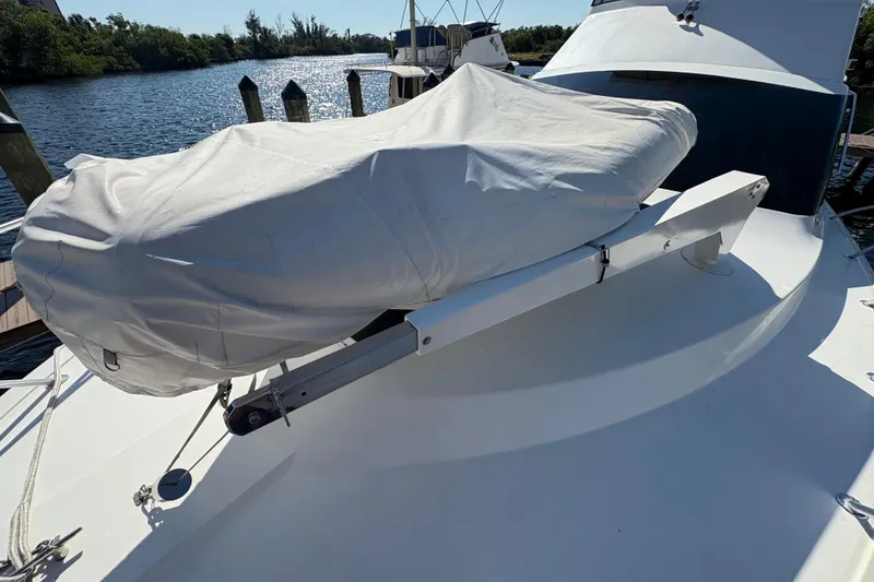 Slide: The Image of 1996 Ocean Yachts 48 Super Sport with covered equipment on deck, docked by the water. - 38