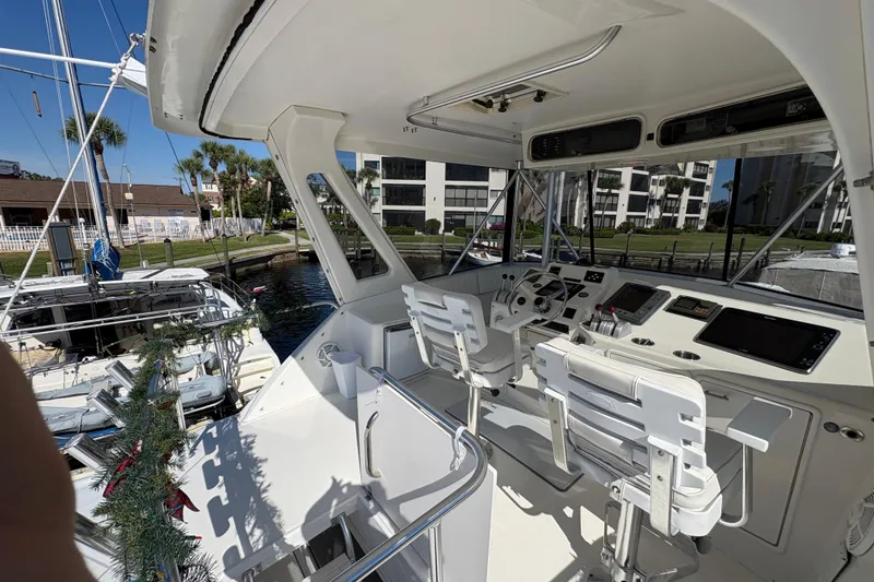 Slide: The Image of 1996 Ocean Yachts 48 Super Sport cockpit with helm, chairs, and marina view. - 4