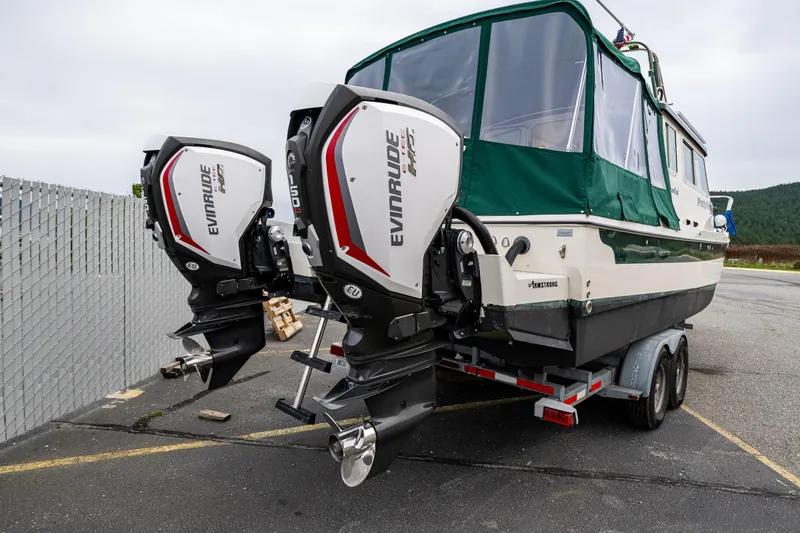 Slide: The Image of 2006 C-Dory 25' Tomcat Catamaran with dual Evinrude engines on trailer. - 12