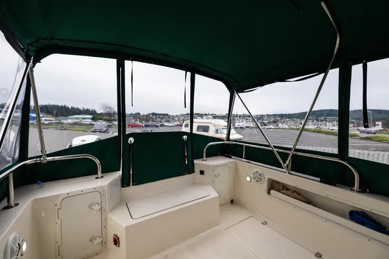 Slide: The Image of 2006 C-Dory 25' Tomcat Catamaran interior with green canopy, docked at marina. - 15
