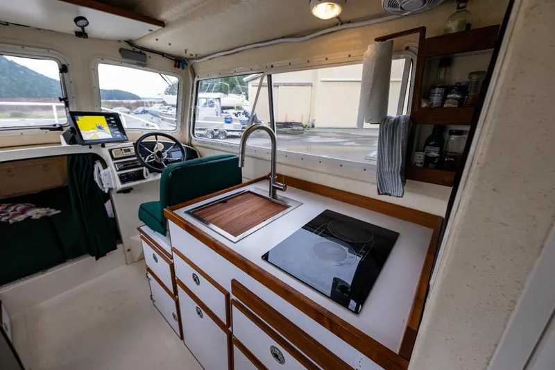 Slide: The Image of Interior of a 2006 C-Dory 25' Tomcat Catamaran with kitchen and navigation area. - 19