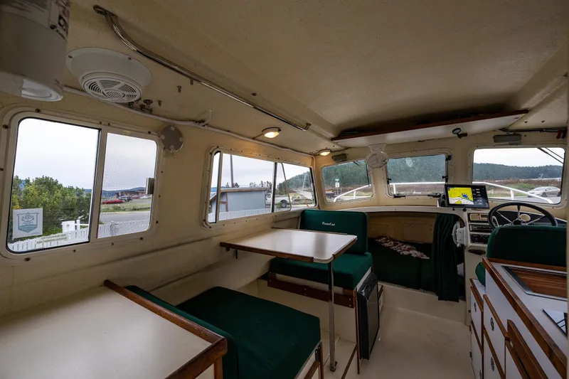 Slide: The Image of Interior of 2006 C-Dory 25' Tomcat Catamaran with green seating and navigation equipment. - 20