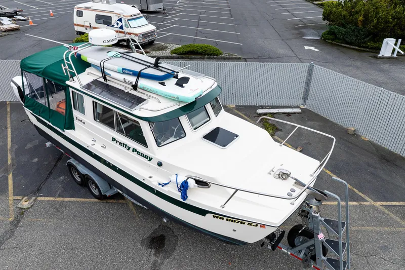 Slide: The Image of 2006 C-Dory 25' Tomcat Catamaran on trailer in parking lot, with green canopy. - 5