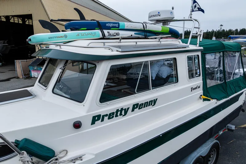 Slide: The Image of 2006 C-Dory 25' Tomcat Catamaran with paddleboards on roof, named "Pretty Penny." - 7