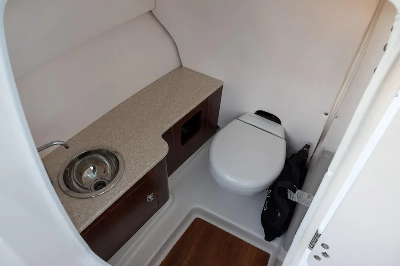 Slide: The Image of 2020 Robalo R247 Dual Console boat interior with sink and toilet. - 10