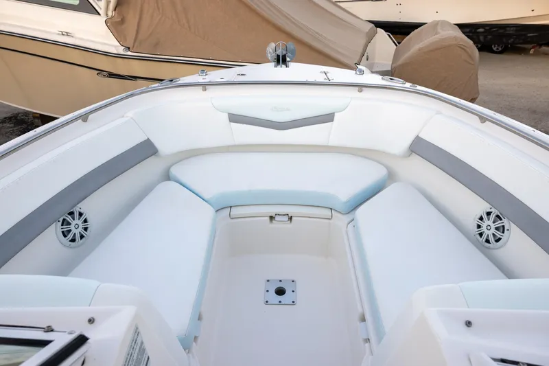 Slide: The Image of 2020 Robalo R247 Dual Console boat interior with cushioned seating and speakers. - 11