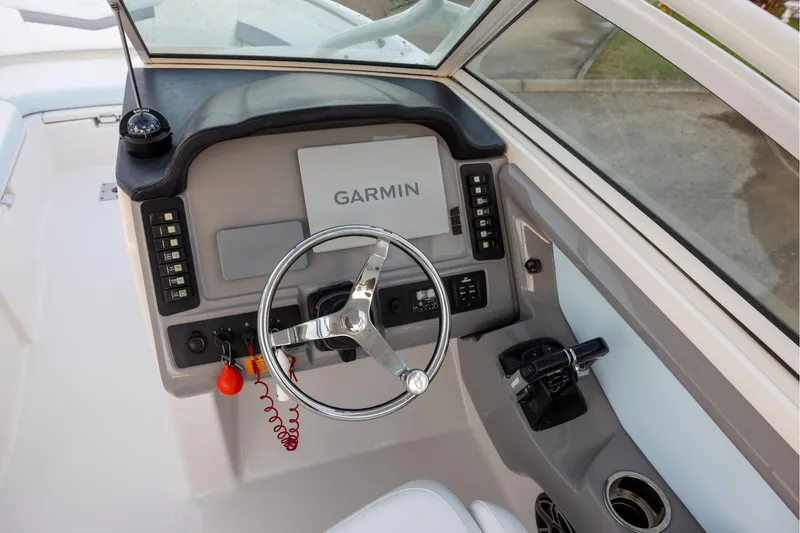 Slide: The Image of 2020 Robalo R247 Dual Console helm with Garmin display and steering wheel. - 7