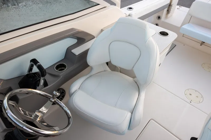 Slide: The Image of 2020 Robalo R247 Dual Console boat interior with steering wheel and captain's chair. - 9